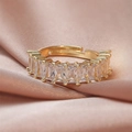 Detailed close-up of golden adjustable ring with baguette-cut zircon on pink silk - White Rectangle Zircon/Row Ring