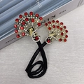 Chignon élégant en forme de paon avec strass rouges et finitions dorées sur noir - Paon Or Rouge