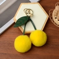 Détail du porte-clés cerise en peluche jaune avec feuille en cuir et fermoir doré - Jaune