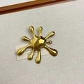 Macro shot of gold liquid fluid brooch on a rustic linen cloth and wood background - 39 Gold Fireworks (Z-4114)