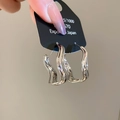 Detailopname van onregelmatige zilveren oorbellen in vloeibare metaalstijl met 925-merk - Zilver (S925 Zilveren Naald)