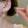Pendientes de estrella de plata con cristales azules en modelo en vista de primer plano - 50# Pin de Plata - Plata Azul