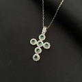 Collana con croce in argento con zirconi verdi e trasparenti su sfondo scuro - Croce in Zirconia Verde Argento