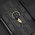 Macro detail of elastic beaded ring featuring golden wing charm and black faceted beads - Black Bead Wing Style (F-R584)