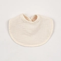 Detailed close-up of soft beige cotton baby bib showing absorbent crinkle muslin texture - Off White