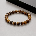Detailed top view of 8mm yellow tiger eye stone beads with silver metal spacers on a grey surface - Tiger Eye (KB183240-TLX)