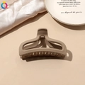 Macro detail of a beige matte claw clip for hair on a textured fabric and ceramic plate - Milk Coffee Matte-Fishtail
