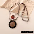 Detail view of double-layer bow necklace with long adjustable cord from 80 to 100cm - Gold Spiral Disc Style