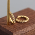Macro detail of gold-plated twisted hoop earrings with micro-pave white cubic zirconia - S-E1380-Gold Twisted Zircon