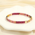 Macro view of colorful enamel Tila beads on elastic bracelet over shell plate - BR1670-I/Pink Rose Black Gold Mix