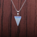 Macro shot of triangle opal stone pendant on a delicate silver metal chain necklace - Opal Triangle
