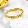 Detail of golden tiered gear style bracelet with scalloped edges on white silk base - Gold