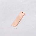 Gedetailleerde macro-opname van een roségouden rechthoekige metalen tag voor DIY-sieraden - Roségoud