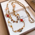 Detail of vintage flower beaded necklace with red and gold accents in a wood jewelry box - Red and Gold/Retro Elegant