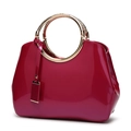 Glossy magenta patent leather handbag with textured golden metal ring handles - Rose Red