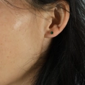 Minimalist green rounded stud earring shown as a single lobe piercing on a model - 3mm / Green