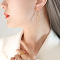 Pendientes de doble aro dorados y anillo de corazón en una modelo femenina - Pendientes / Dorado