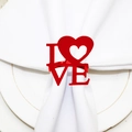 Red metal LOVE heart napkin ring shown on a white napkin and gold-rimmed dinner plate - Red LOVE Heart