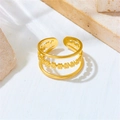 Detail view of triple-layered golden flower ring on a natural stone background - Small Flower Three-layer Open Ring