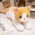 Süße orange-weiße Plüschkatze mit blauen Augen und flauschigem Fell in Liegeposition - 45cm / Orangefarbene Ragdoll-Katze