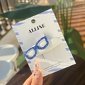 Detail of creative blue polka dot glasses hair clip on branded card display - Pure White Glasses BB Hair Clip