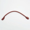 Macro detail of wine red leather handbag handle with pre-punched stitching holes - Tan