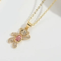 Dettaglio di un ciondolo a orsetto in oro 18K con pietra rosa e cristalli micro-pavé - Rosa