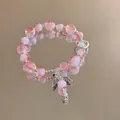 Close-up of pink beaded bracelet with crystal beads and an angel wing pendant - Pink-White