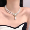 Detail of a double-layered pearl necklace with flower and teardrop pendants on a model - 10# Necklace—Waterdrop Double Layer Pearl