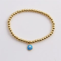 Minimalist gold beaded bracelet featuring a blue evil eye enamel charm for women - Blue