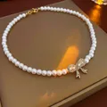 Elegant white pearl necklace featuring a golden rhinestone bow pendant variant - White-Bow