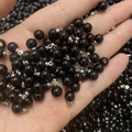 Hand holding polished black pearl pendant charms with silver metal loops for jewelry making - Black Pearl Silver Eye Pin