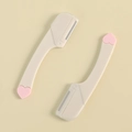 Mini rasoir à sourcils avec manche beige, détail cœur rose et capuchon de protection - Pièce Unique en Vrac / Blanc laiteux