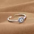 Silver Evil Eye open ring with blue and white cubic zirconia on brown textured background - Evil Eye Disc Style (Q-J072) / White Gold