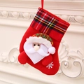 Calza di Natale rossa con Babbo Natale e bordo a scacchi appesa al camino bianco - Babbo Natale