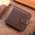 Brown vintage PU leather bifold wallet with snap closure on a dark wooden background - Coffee