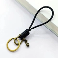 Porte-clés en cuir tressé noir fait main avec anneau en D en laiton et petite clochette - Corde en Cuir Noir Boucle Fer à Cheval Bronze avec Perle