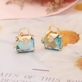 Macro view of blue gemstone handbag earrings with a sparkling crescent moon detail - Lake Blue