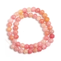 Vista macro di perle tonde in vetro floreale rosa e arancio per gioielli fai-da-te - Pesca