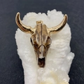 Detailed view of an acrylic bull skull pendant with gold horns on a white crystal base - No.3 White Brown Texture with Gold Horns
