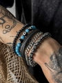 Close-up of four-piece beaded bracelet set featuring blue evil eye and silver cross charms - S1558/5-Piece Set