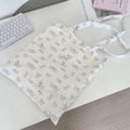 Détail d'un sac cabas blanc en toile avec motifs de chats bleus et étiquette tissée - Blanc
