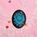 Dettaglio macro del rilievo rosa blu su base nera posata su pizzo rosa - Floreale Nero Blu