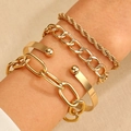 Detail of four-piece gold bracelet set with twisted and paperclip chain on female wrist - Gold (4176)