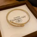 Twisted cable open cuff bracelet in gold finish with spherical end caps on gift card - 55# Twisted Cable Cuff with Ball Ends / Gold