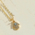 Goldene Hamsa-Hand-Halskette mit blauem Evil Eye Anhänger und glitzerndem Zirkon-Besatz - Weißes Öl-Fatima-Hand