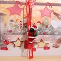 Close-up of electric Black Santa Claus climbing a red ladder for Christmas decor - Black Man Climbing Red Ladder