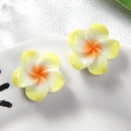 Detail shot of resin Plumeria flowers with yellow and white gradient petals on a plate - Small Yellow