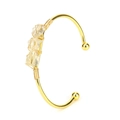 Macro shot of three natural raw citrine stones hand-wrapped on a gold open cuff bracelet - Citrine