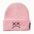 Pink knitted beanie with black XX sad face and juice box embroidery on a white background - Pink